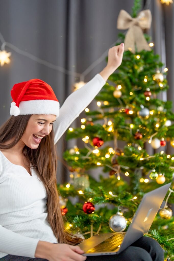 Woman looking at the computer surprised at Christmas to see that she has won the lottery